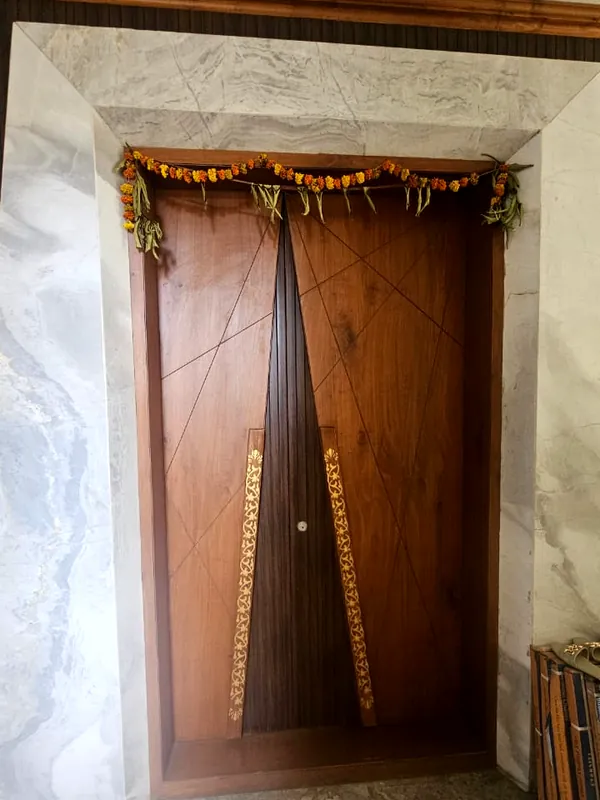 A brass-inlaid door framed in marble.